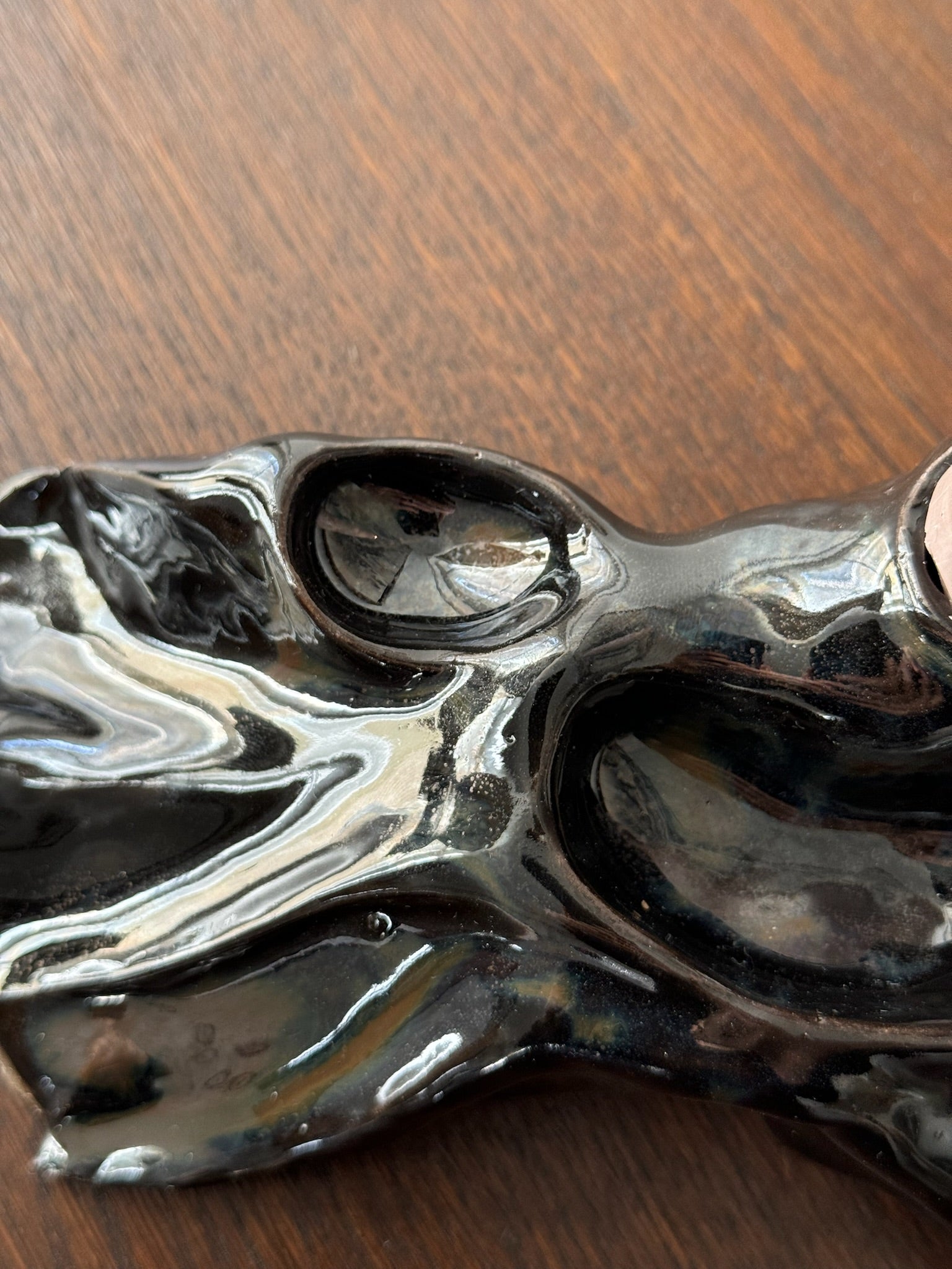 Detail of a black candleholder by Aline Schwörer resembling a geological texture.