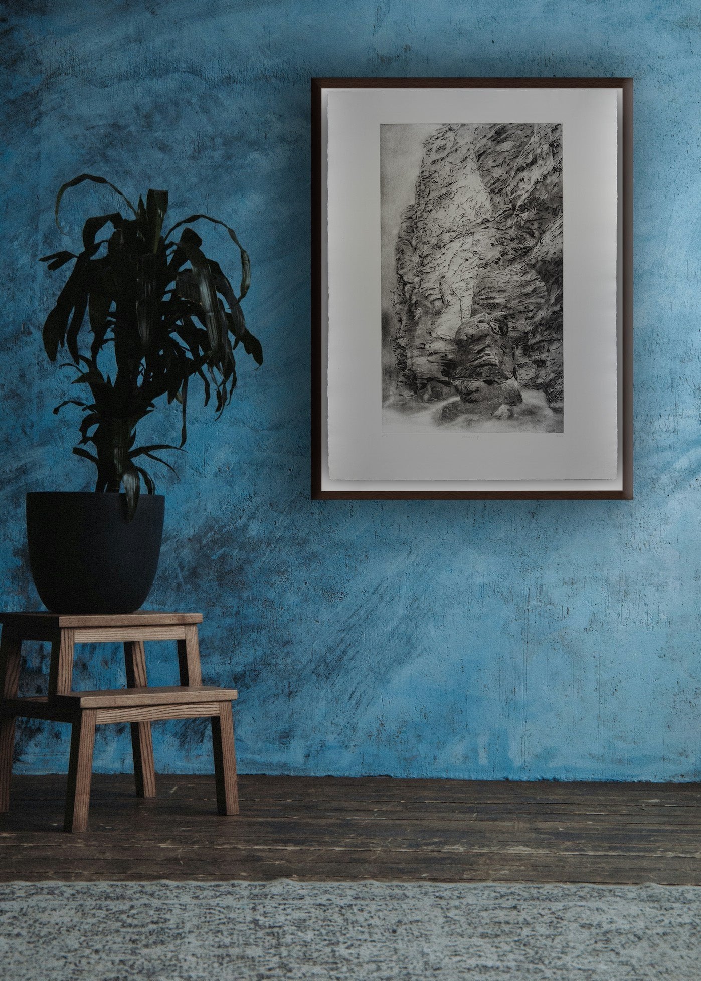 Big format black and white etching in frame in a room with blue walls by Erika Richter