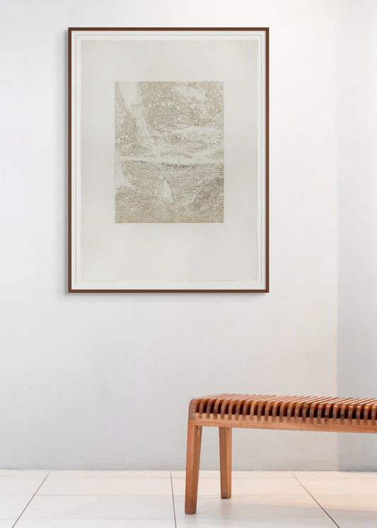 Framed abstract art on a white wall with a wooden bench below.