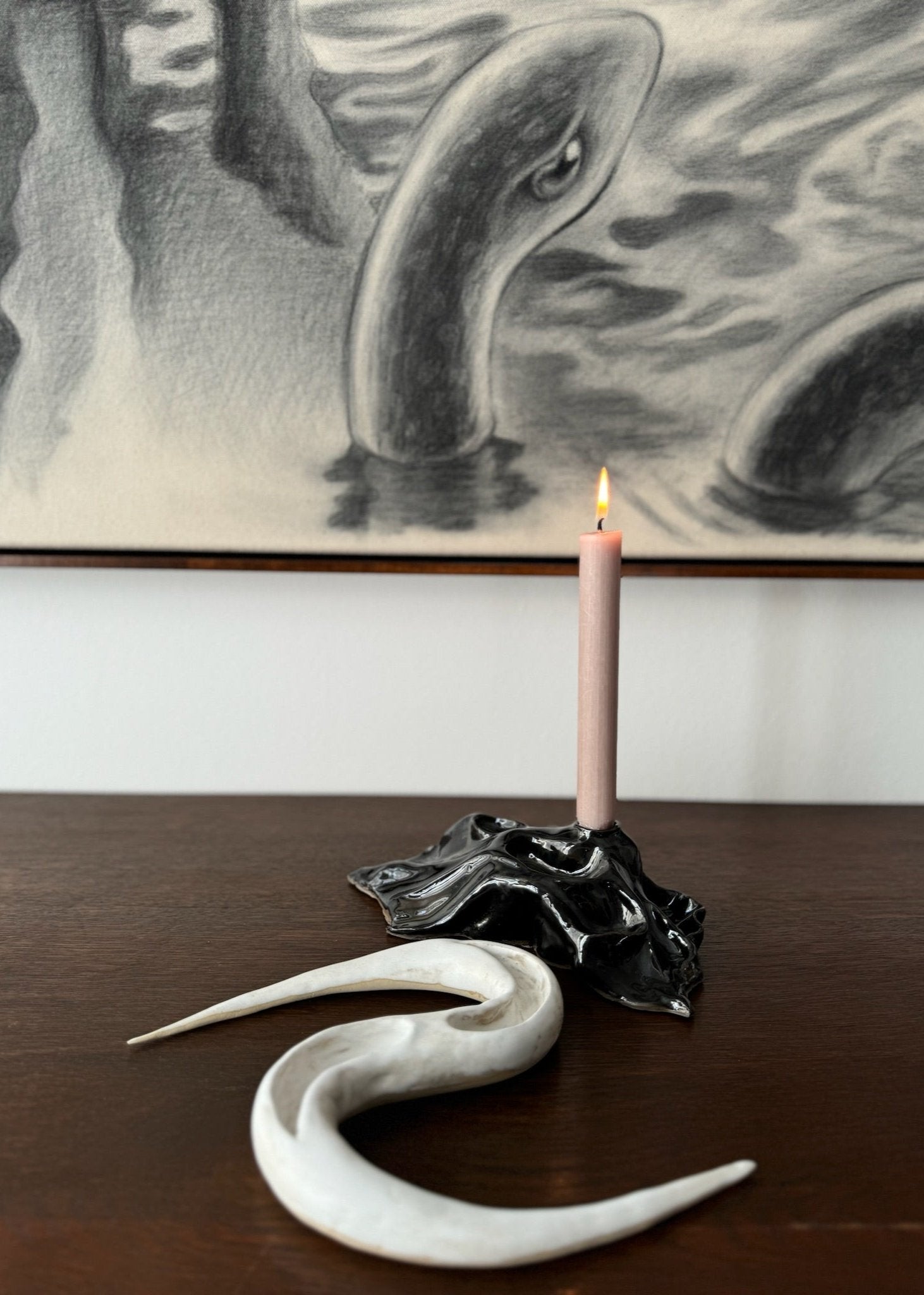 Black candleholder and white ceramic artwork by Aline Schwörer