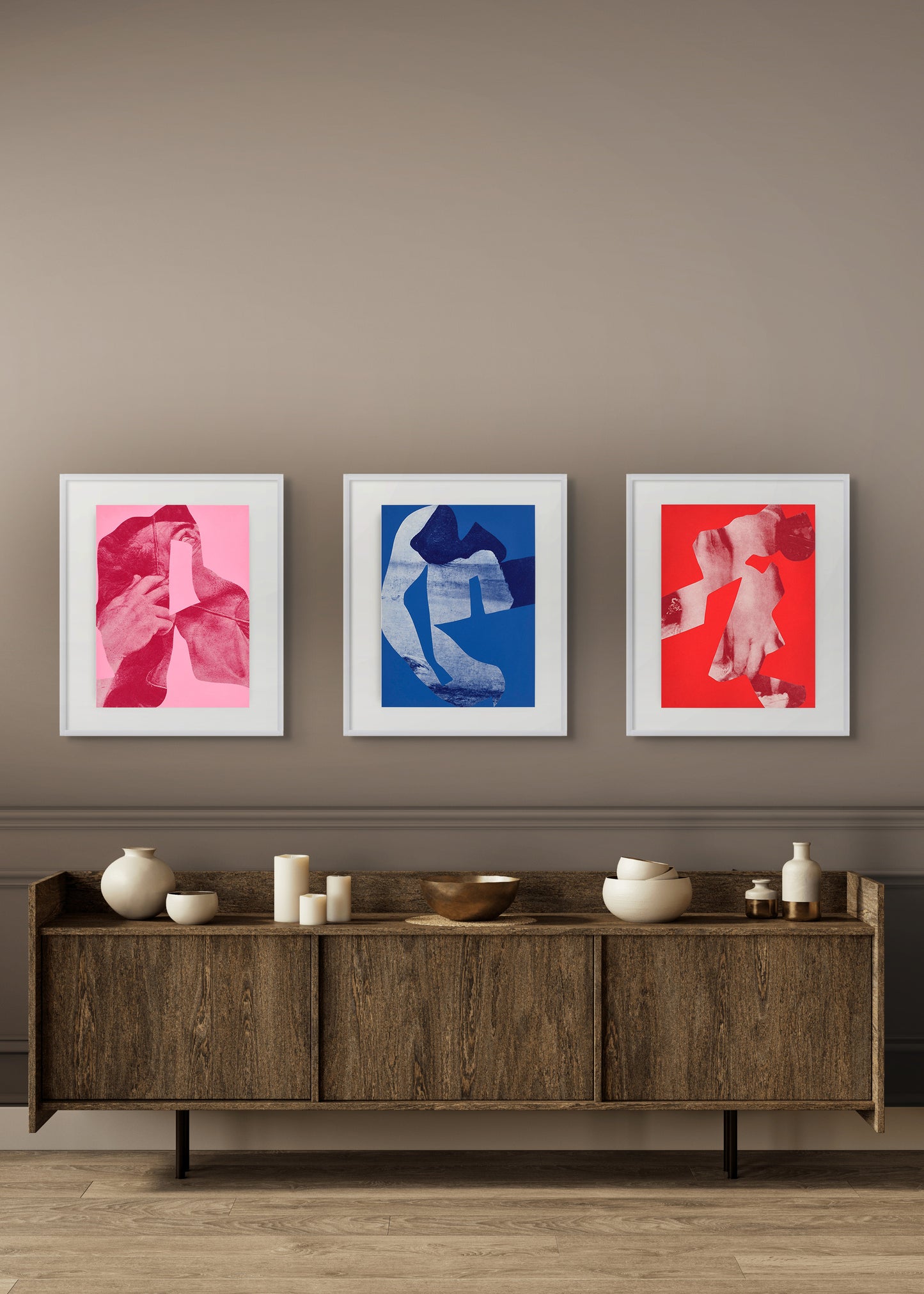 Three framed artworks by Arturo Herrera on a wall above a wooden sideboard with decorative items.