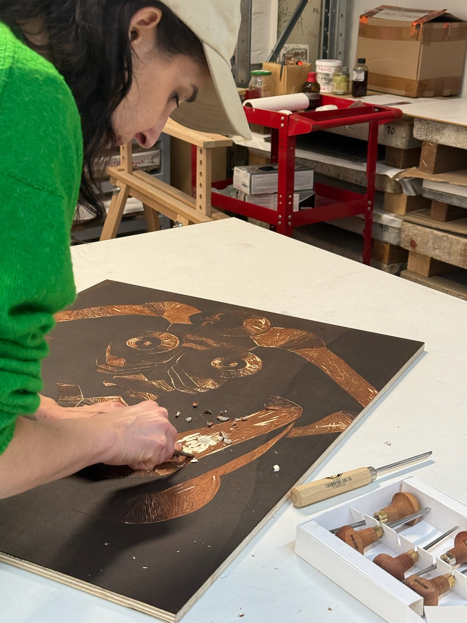 Artist working on a woodcut print in a workshop setting