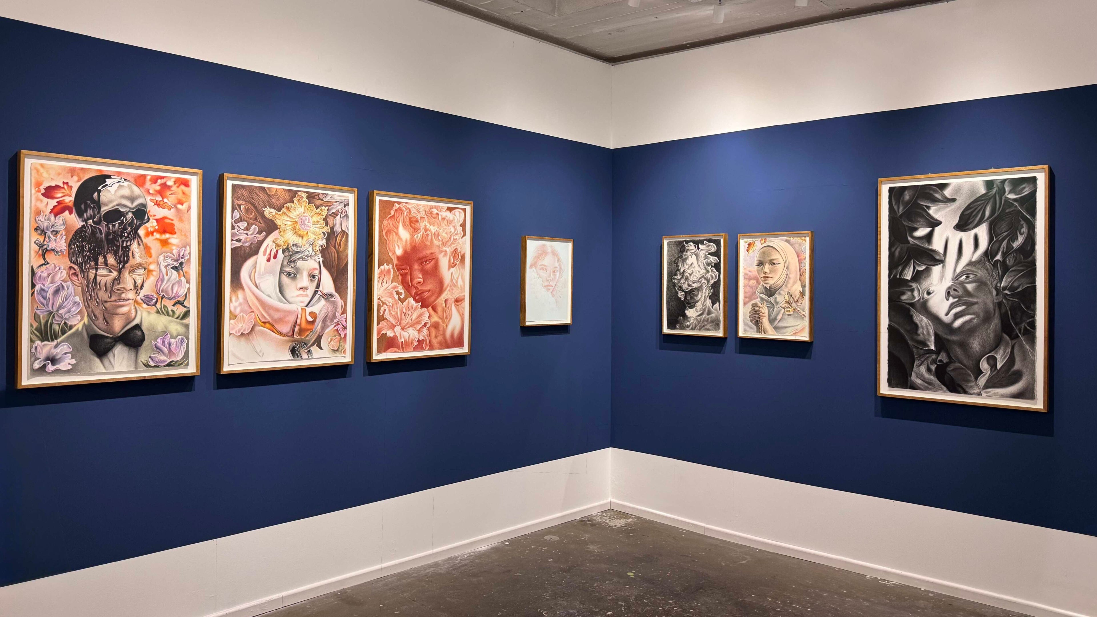 framed artworks by Dennis Scholl on blue walls