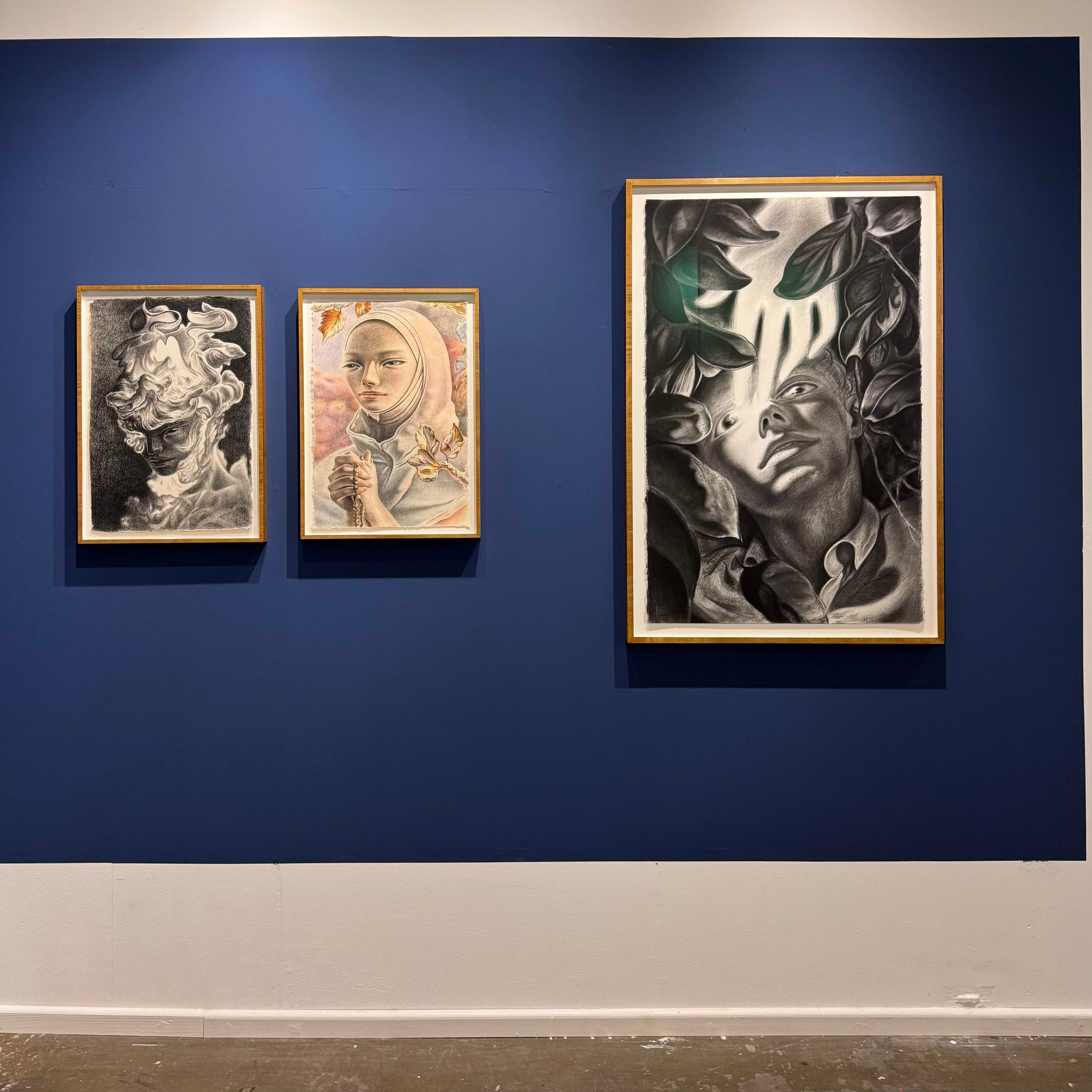 Three framed artworks by Dennis Scholl on a blue wall