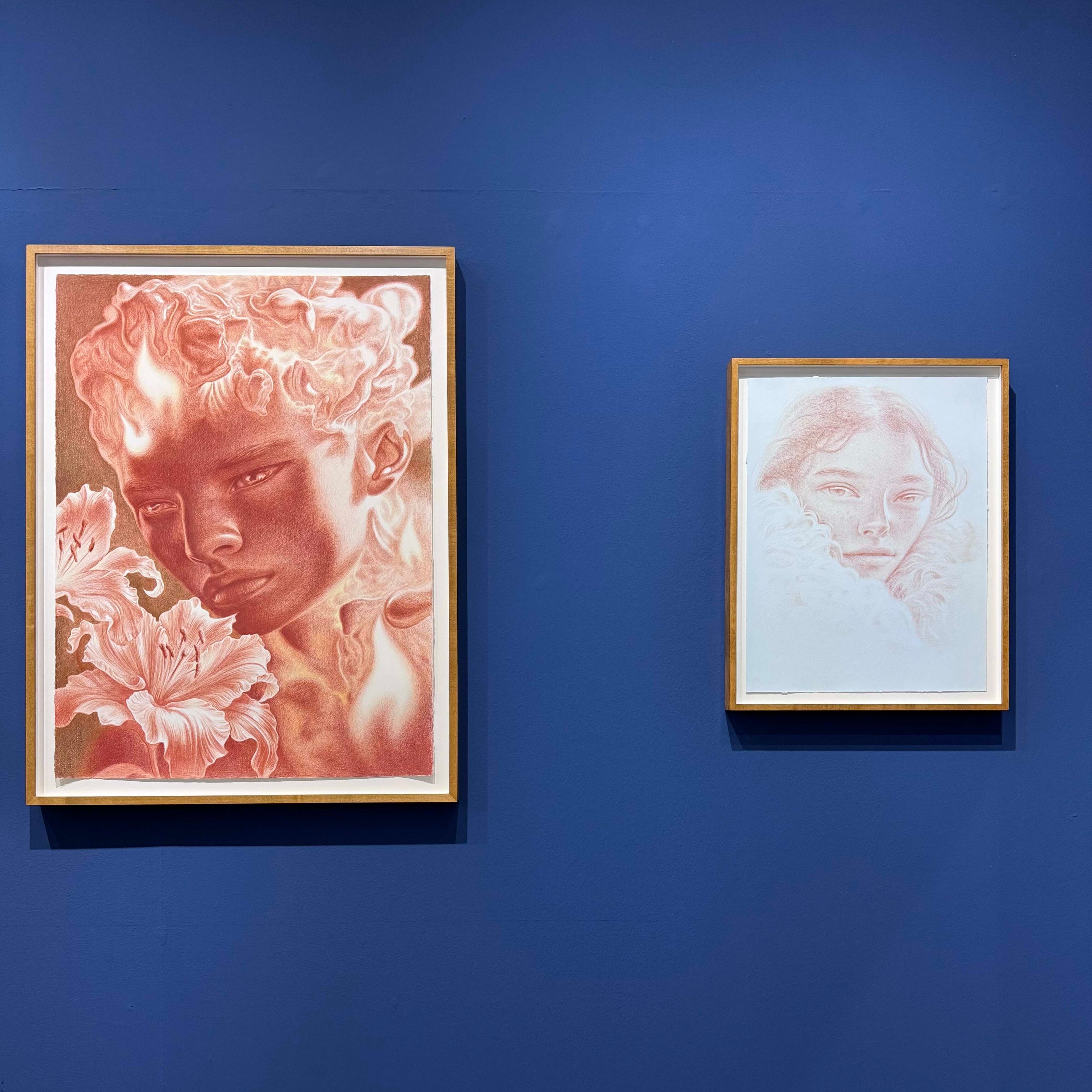 Two framed artworks by Dennis Scholl on a blue wall