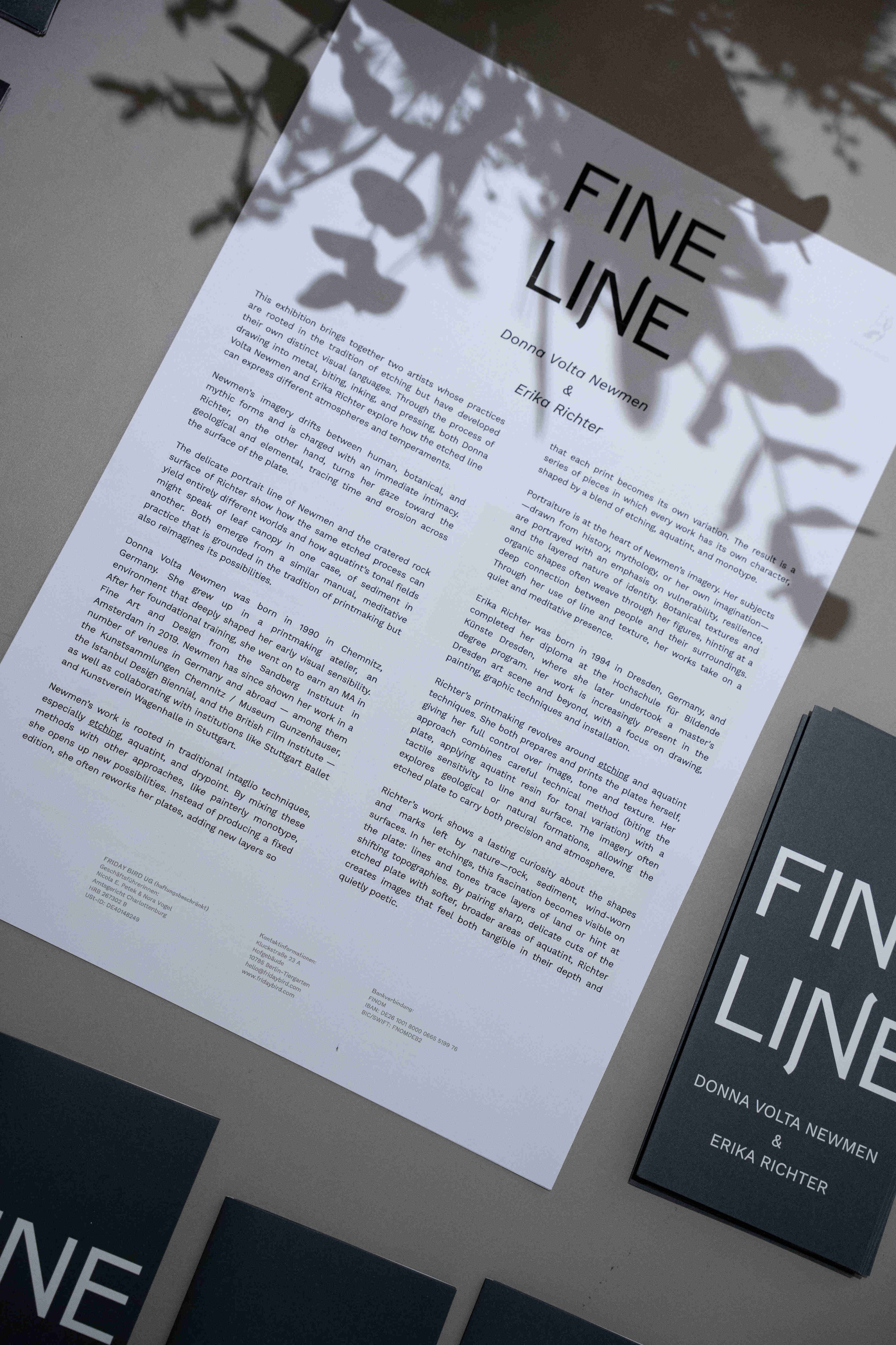 Text about exhibition 'FINE LINE' by Friday Bird on a surface with shadows.