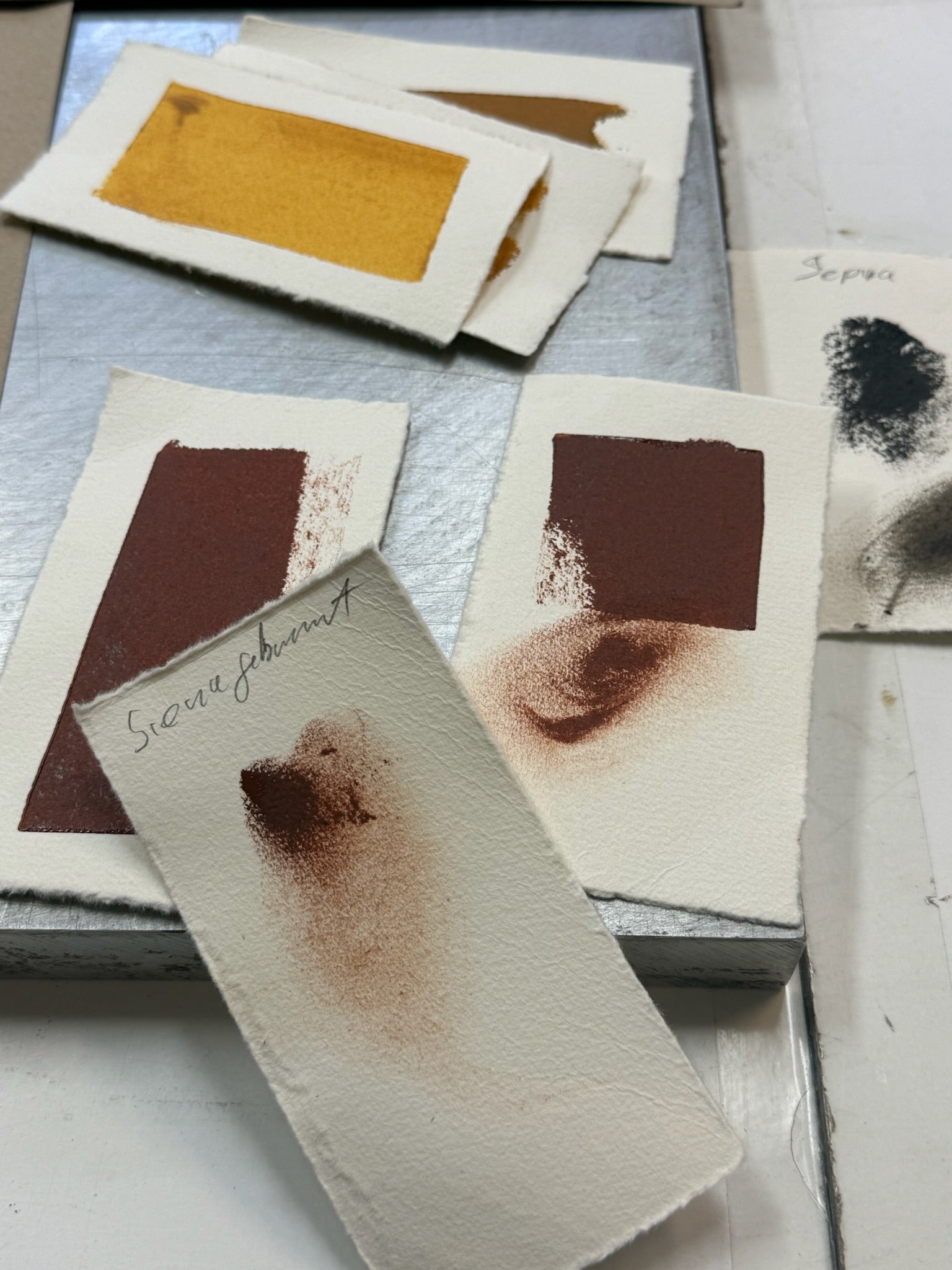 Color swatches with brown and black ink in a printmaking workshop