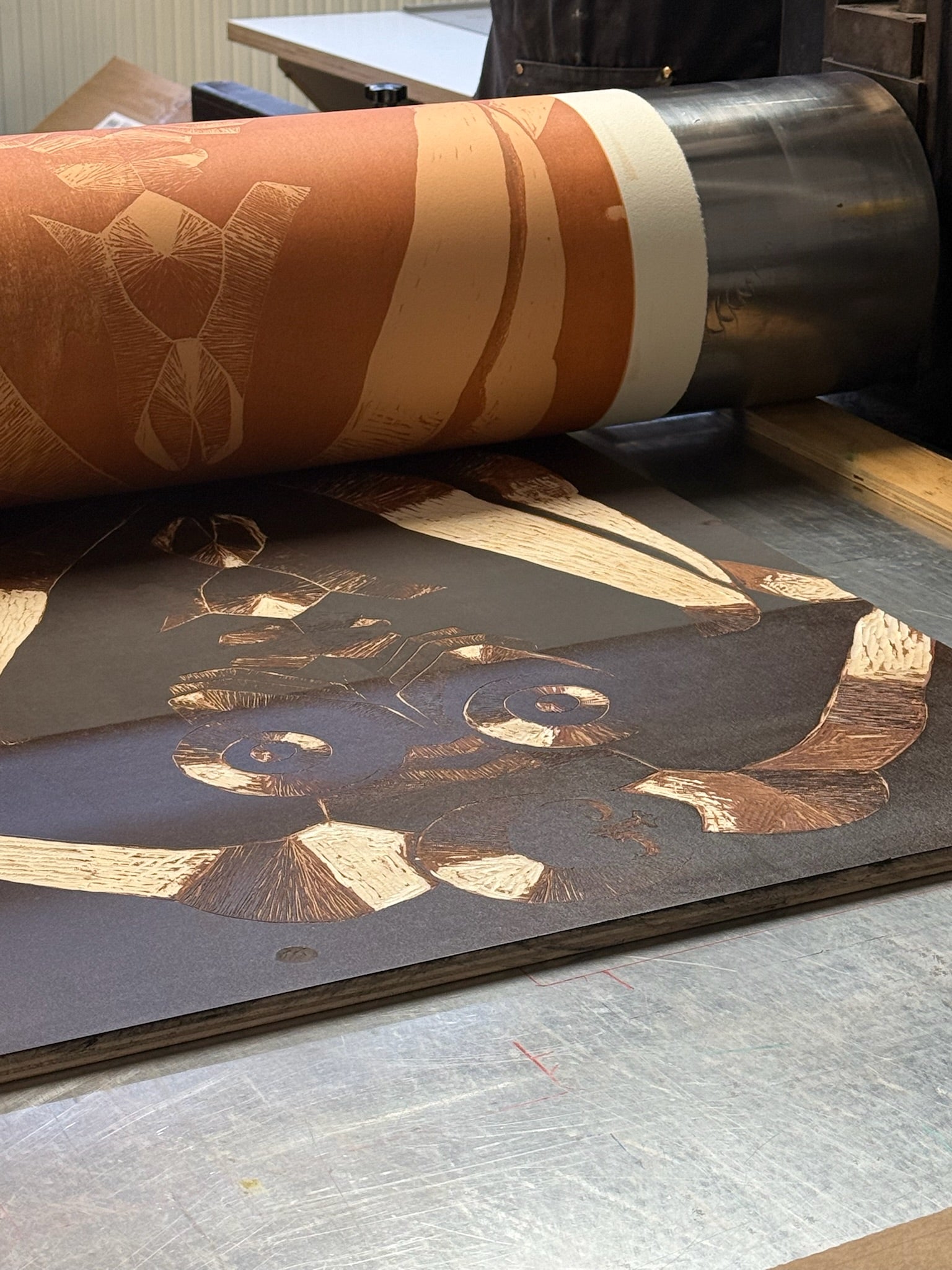 Woodcut in the moment of printing on the printing press.