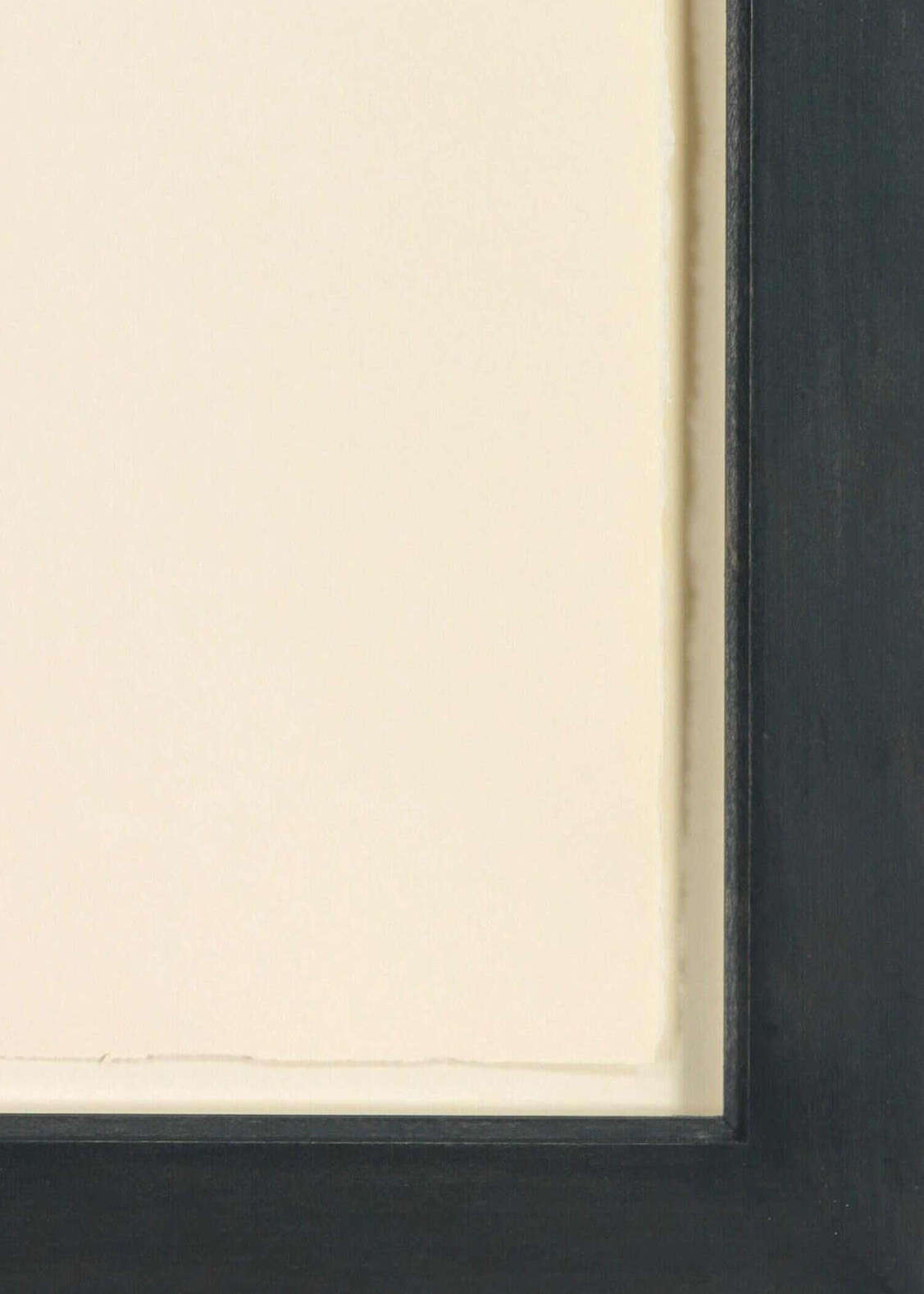 Close-up of a black frame with a white mat on a neutral background